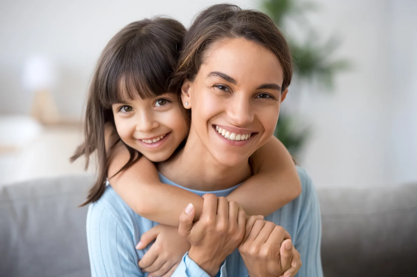 a woman is giving a little girl a piggyback ride .