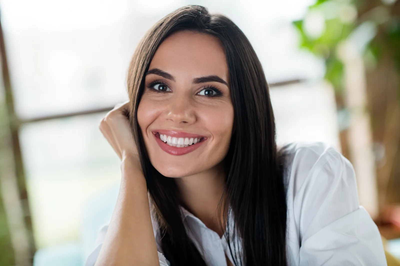 a close up of a woman 's face with long hair smiling .